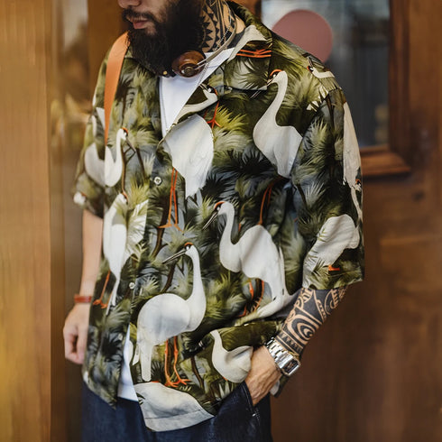 Person wearing a shirt with a tropical bird pattern in an indoor setting